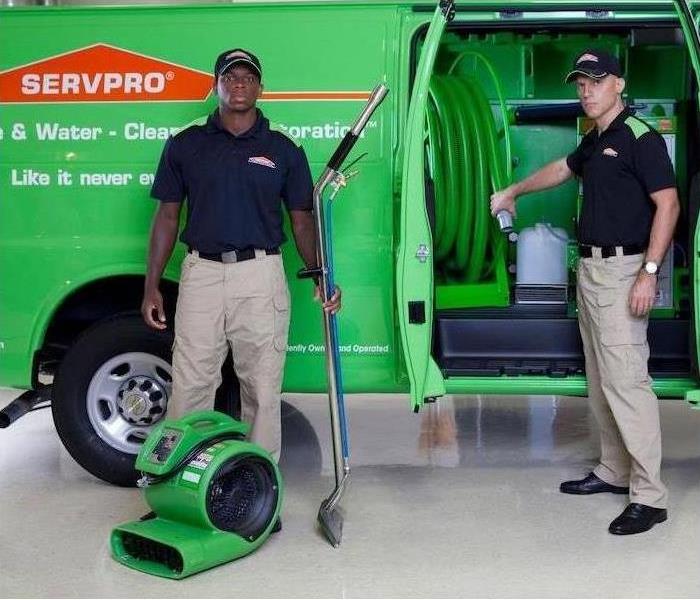SERVPRO technicians with equipment in front of truck.